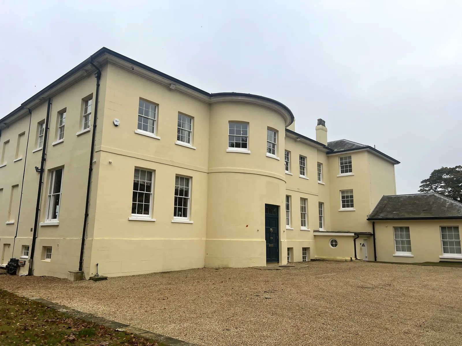 The curved bay end of the house and the single-storey service wing beyond.