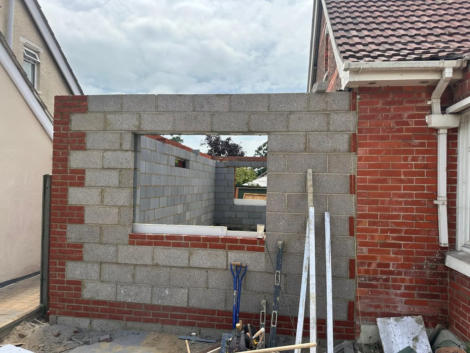A window opening formed in blockwork with brick reveals and a brick cill beneath.