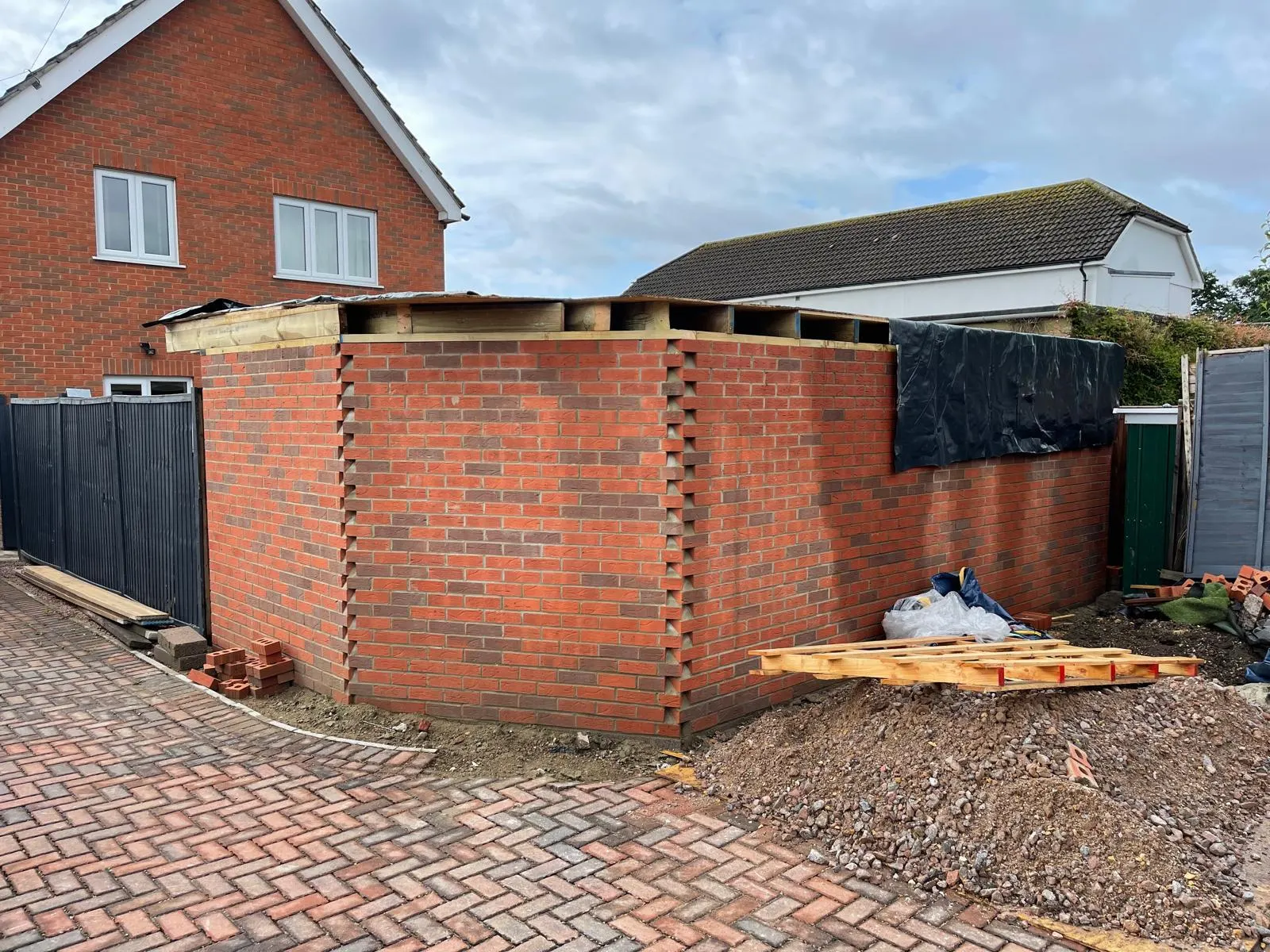A brick extension with the roof joists set over, a toothed brick course run below the eaves.
