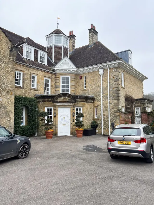 The exterior of a private family home in Midhurst, seen across its established garden.